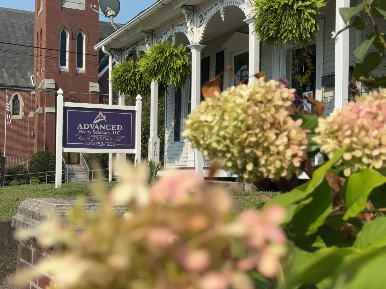 Advanced Realty signage with artistic flowers in the foreground